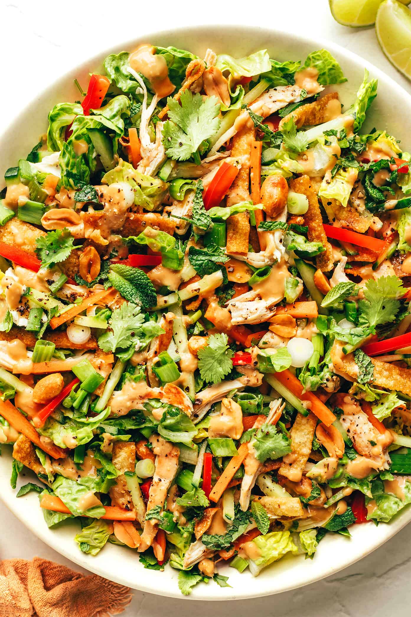 Thai Crunch Salad in bowl drizzled with peanut dressing
